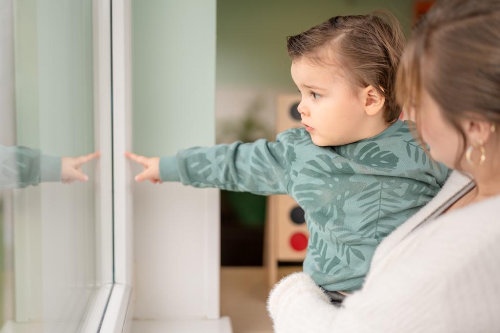 kind wijst naar raam