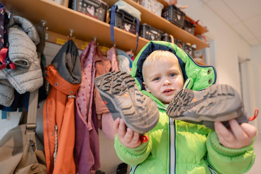 Kind houdt twee schoenen vast 